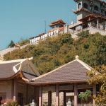 Trung Son Co Tu Pagoda on a sunny hillside, showcasing traditional architecture and vibrant natural surroundings.