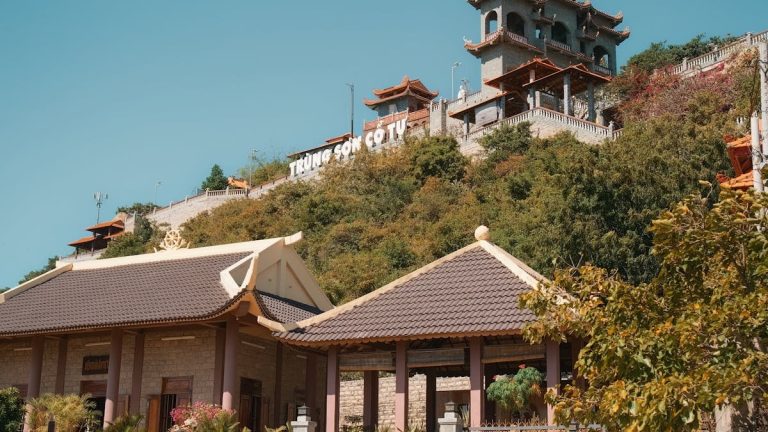 Trung Son Co Tu Pagoda on a sunny hillside, showcasing traditional architecture and vibrant natural surroundings.